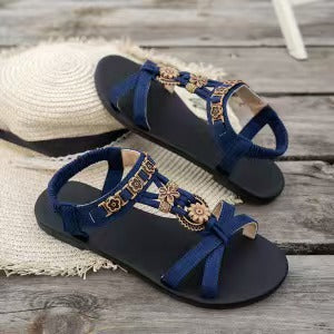 👡 50% RABATT NU! 🌸 Kvinnors runda tå platta andningsbara sandaler – Blommiga metalldetaljer & justerbar rem – Dämpad fotbädd – perfekt för sommarens långa promenader eller avslappnade dagar ✨🌿
